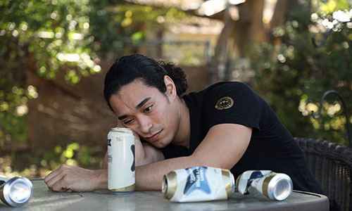 man laying head on arm after drinking too much